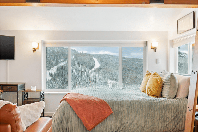 Bedroom at Mogul Hill Ski Condo overlooking snowy Schweitzer Mountain
